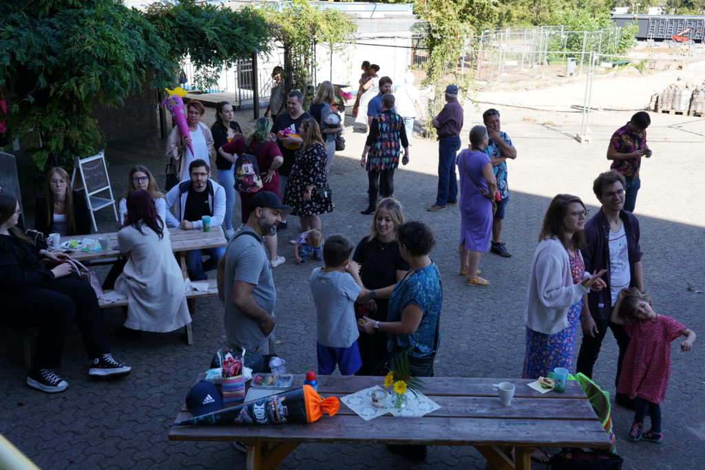 Familien mit Schultüten bei Kaffee und Kuchen auf dem Schulhof